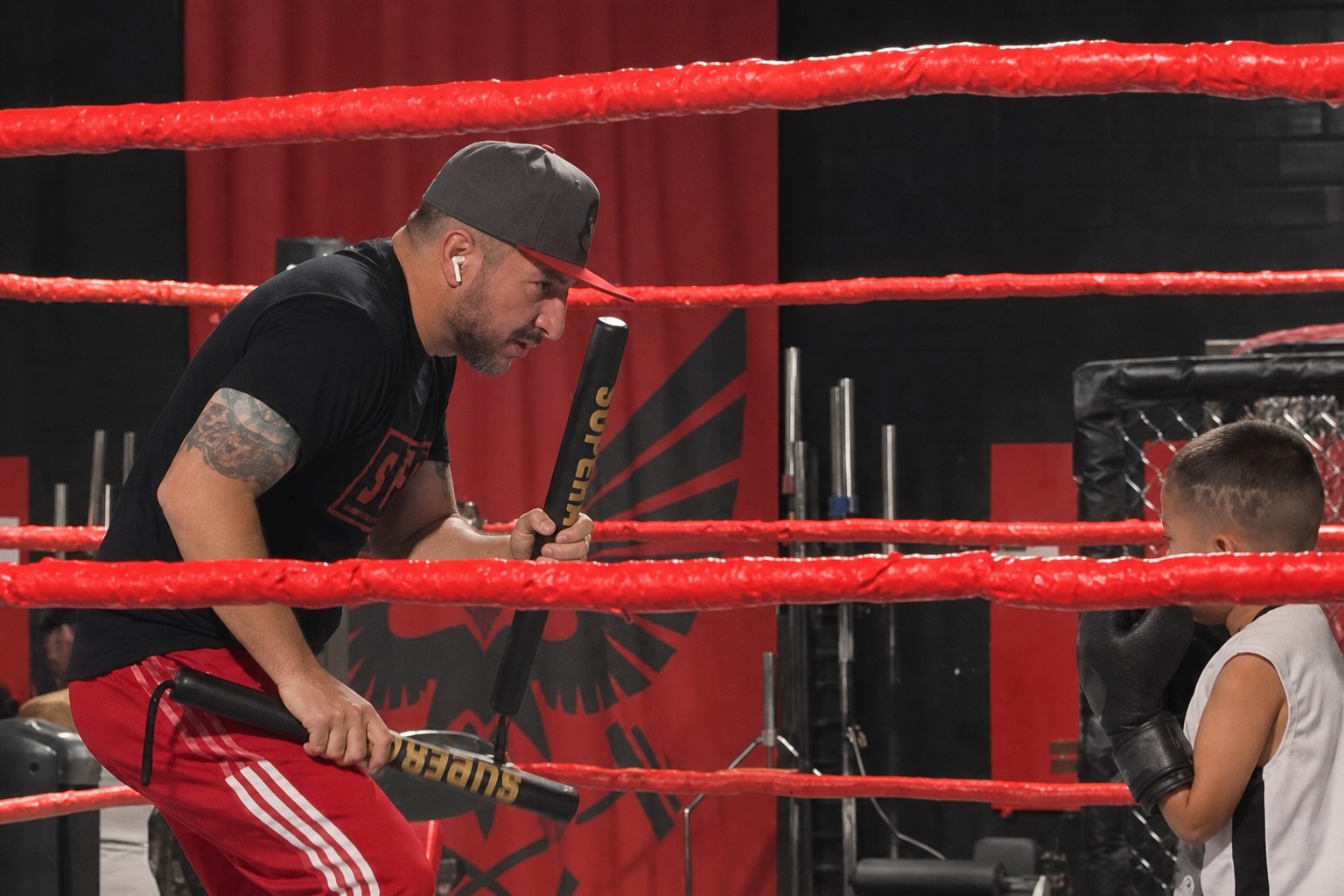 Coach working with a youth boxer in the ring. Still from a public Coach Paco Instagram reel tagged with House of Aces.